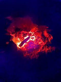 Glowing red embers in the firepit after the flames have died down
